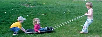 kids with sled on grass